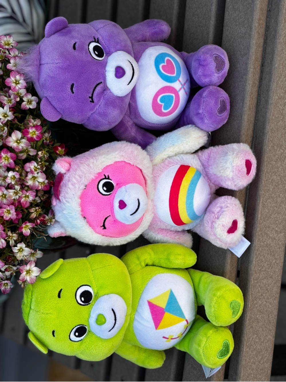 Care Bears Collectible plush toys in green, pink and purple colors.